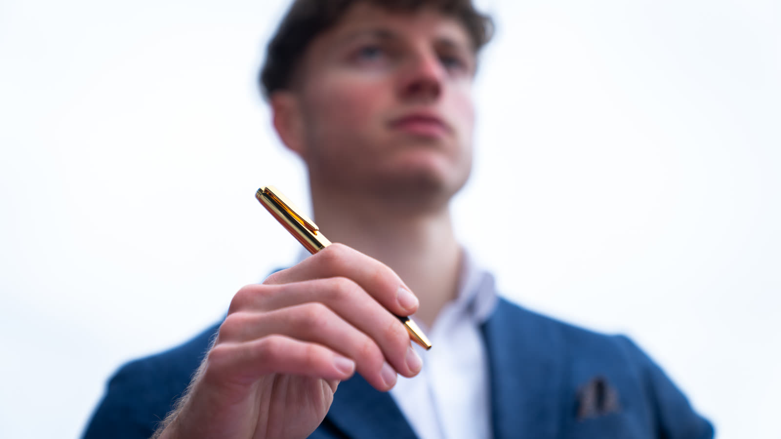 Junger Mann hält einen Hörner-Kugelschreiber, das richtige Schreibgerät für Uni und Ausbildung zum 18. Geburtstag