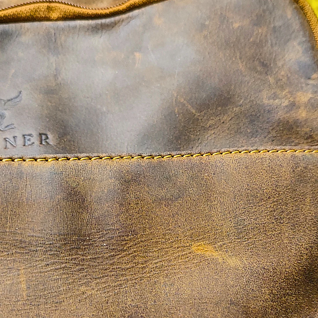 Cognac-Leder des Saxum Lederrucksacks, nach rund drei bis sechs Monaten täglicher Nutzung sichtbar nachgedunkelt mit Glanzpatina