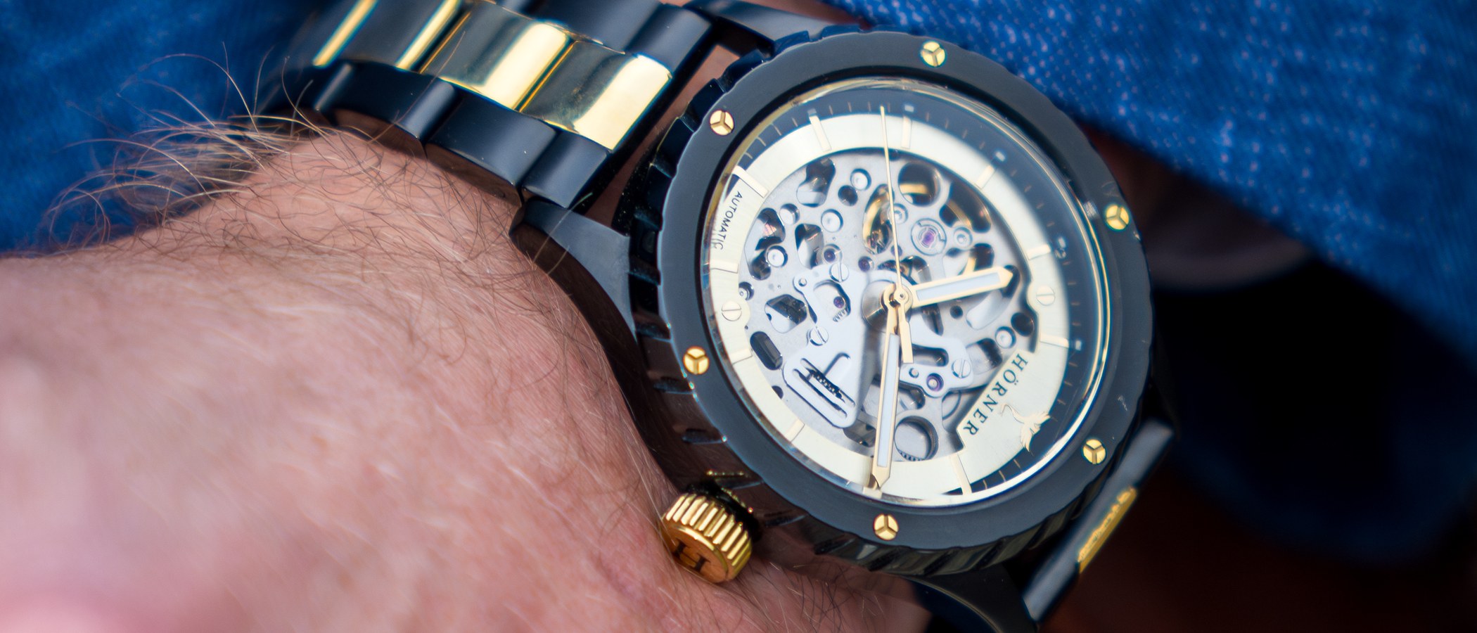 Cadran squeletté d’une montre automatique au poignet, mouvement mécanique visible avec balancier et rouage